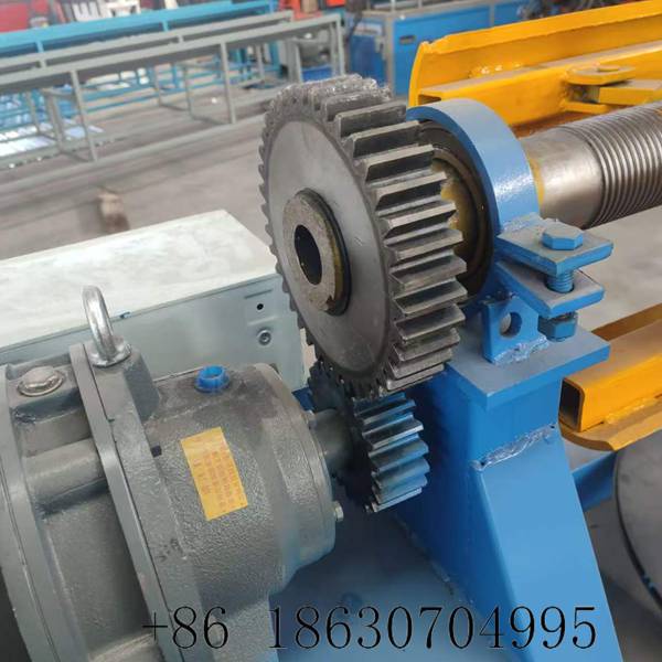 Heavy-duty spur gear and chain drive assembly of the electric decoiler transmitting motor power to the mandrel shaft for smooth constant-speed coil unwinding
