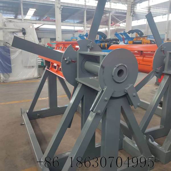 Manual uncoiler side view showing hand-crank expansion handle, mechanical ratchet system, and friction brake for controlled coil unwinding